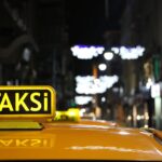 Urban night scene featuring a taxi with glowing lights on a bustling street.